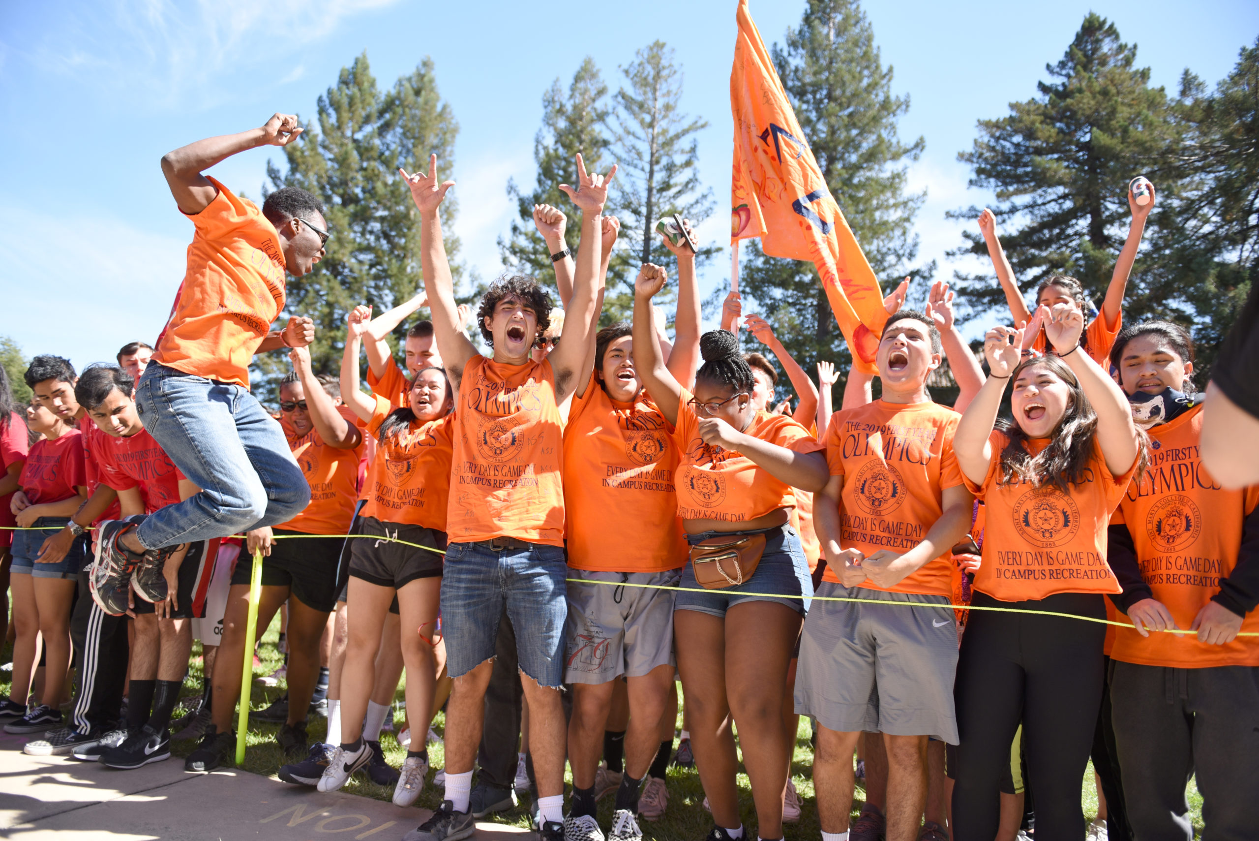 Students wearing orange shirts representing their dorm cheering on De La Salle Lawn