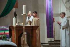 The chapel father holding up a round item