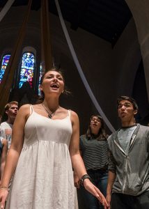 A girl singing during a choir performance in the chapel