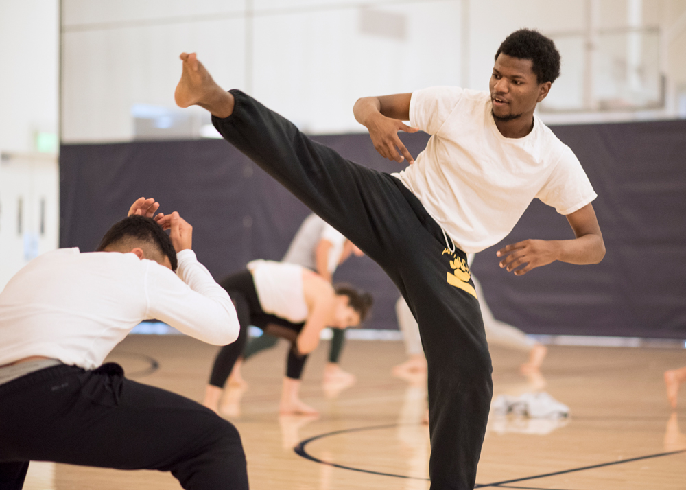 A student doing a high kick in a class about Capoeira during Jan Term