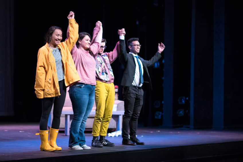 Students smiling and bowing together on the edge of the LeFevre Theatrestage